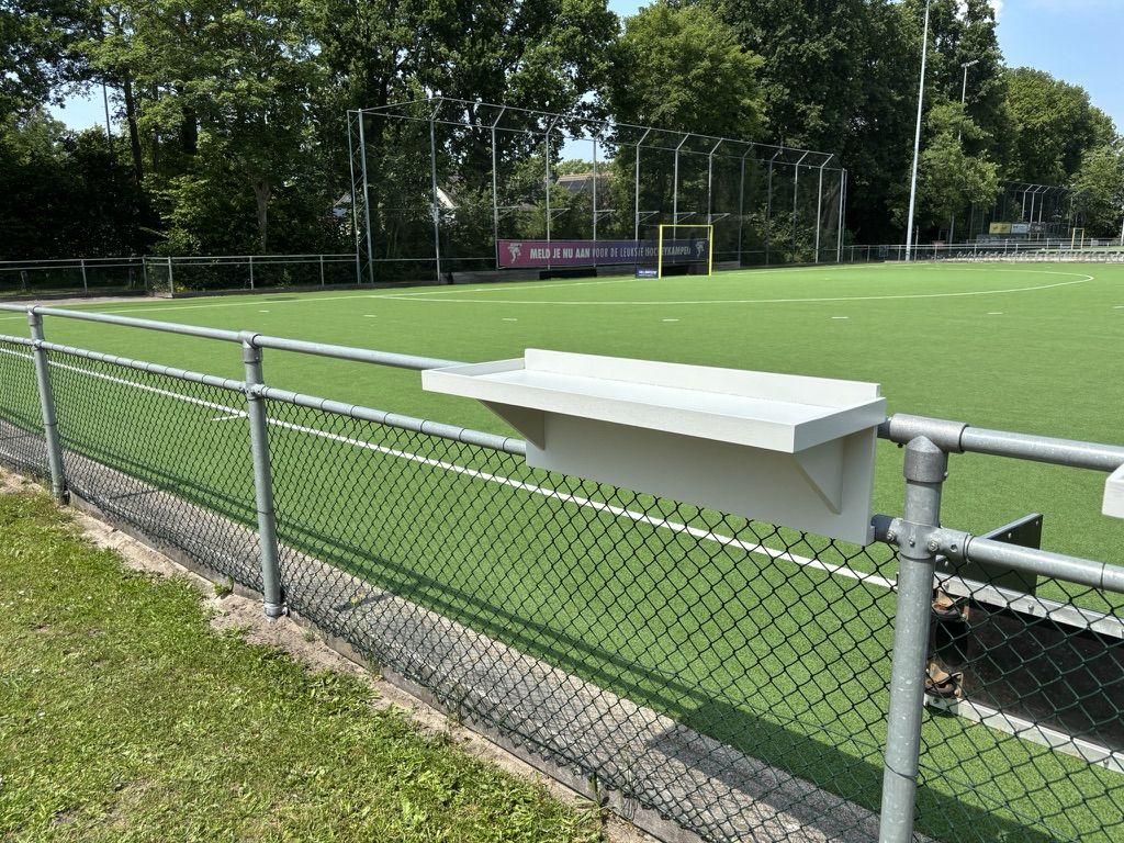 De Veldbar aan het hek langs het veld in de zon