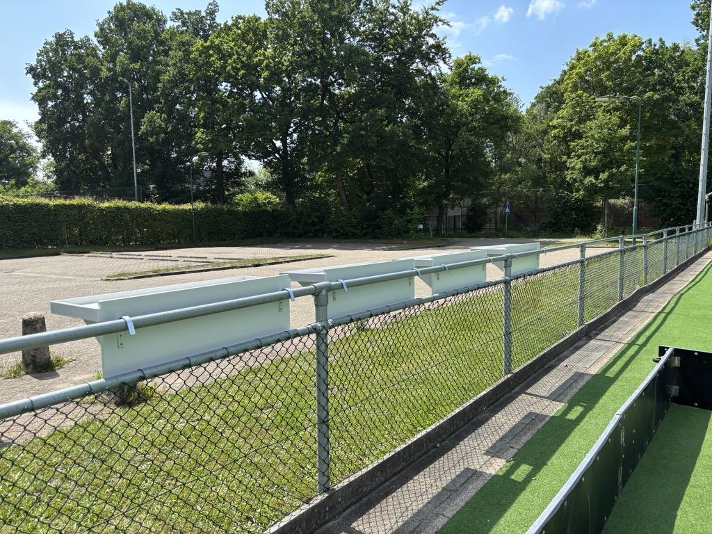 Lange rij Veldbarren in perspectief langs het hek